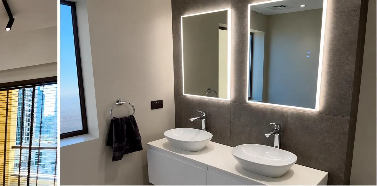 New bathroom with a double vanity and backlit mirrors