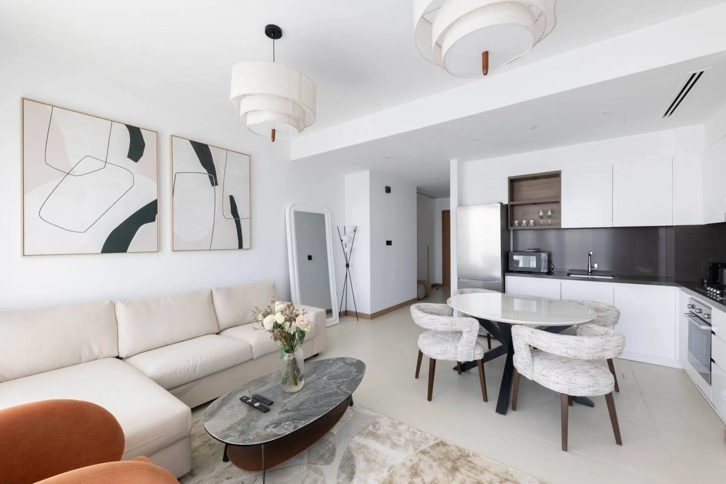 Living and dining area with a pale sofa, stone coffee table and open kitchen
